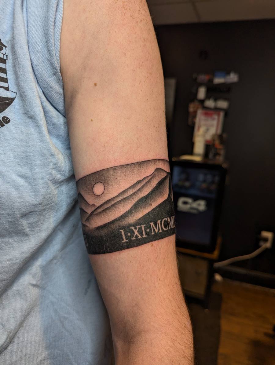 Amphora vase tattoo with sun rays across the shoulder