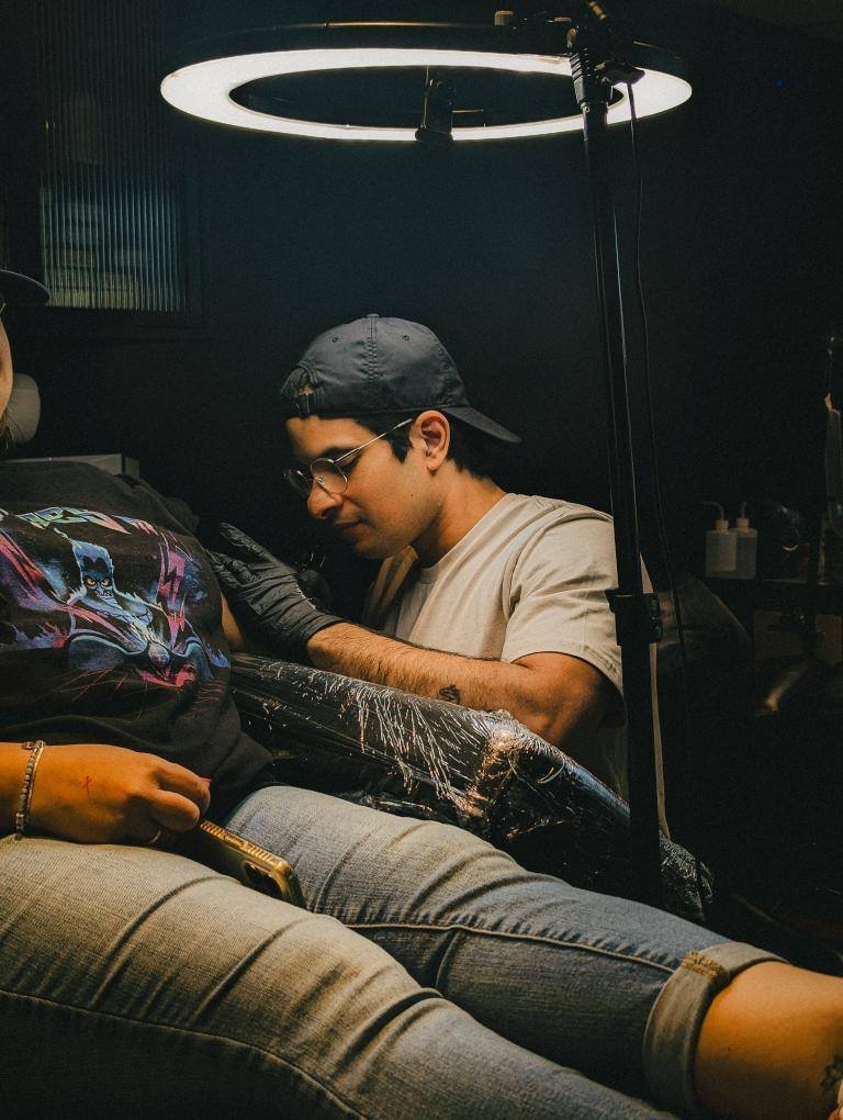 Alexis Omar tattooing a client
